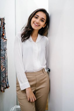 Yeni giyim moda salonu bir alışveriş merkezinde bir montaj odasında çalışıyor bir genç ve güzel Hint Asyalı kadın portresi.