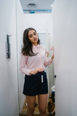 Yeni giyim moda salonu bir alışveriş merkezinde bir montaj odasında çalışıyor bir genç ve güzel Hint Asyalı kadın portresi.