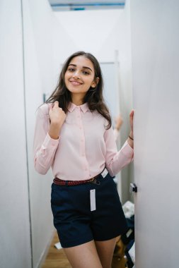 Yeni giyim moda salonu bir alışveriş merkezinde bir montaj odasında çalışıyor bir genç ve güzel Hint Asyalı kadın portresi.