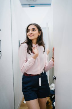 Yeni giyim moda salonu bir alışveriş merkezinde bir montaj odasında çalışıyor bir genç ve güzel Hint Asyalı kadın portresi.