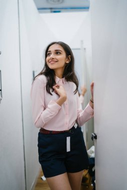 Yeni giyim moda salonu bir alışveriş merkezinde bir montaj odasında çalışıyor bir genç ve güzel Hint Asyalı kadın portresi.