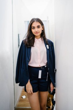 Yeni giyim moda salonu bir alışveriş merkezinde bir montaj odasında çalışıyor bir genç ve güzel Hint Asyalı kadın portresi.