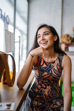 Asya'da hafta sonu seviyor gibi genç ve güzel Hint Asya Singapurlu giysili bir kadına baskı bir kafede oturur.