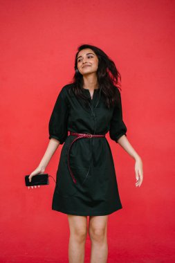 Genç, çekici ve güzel Hint Asyalı kız kulaklıkla müzik dinlerken dans ediyor. O, akıllı telefonunda müzik yayınlıyor.