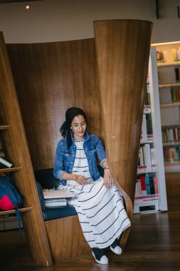 Genç, zarif ve çekici Malezyalı Müslüman kadın gün boyunca elbise ve kot ceket giyiyor..