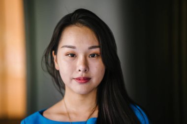 Kendinden emin, genç, güzel ve kendinden emin Asyalı bir kadının portresi.