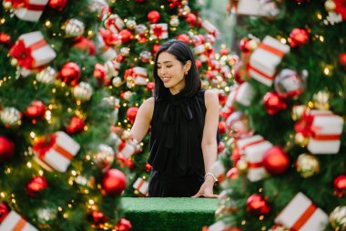 Güzel ve genç bir Kore Asya kadın portresi beholds ve harikası Noel süsleri smiling