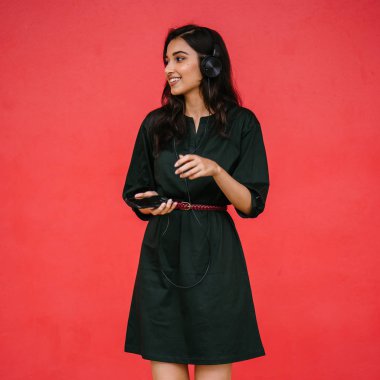 Bir güzel, Genç ve çekici Hint Asyalı kadın bir yeşil elbise ve kırmızı bir arka plan kırmızı kemer Studio portresi