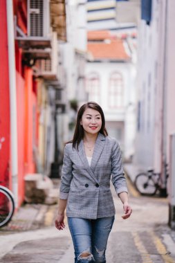 Genç güzel Asyalı kadın bir sokakta yürüyor