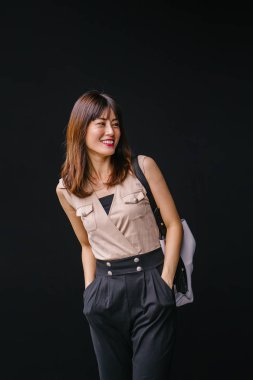 Bir çalışma hanım o pozlar ve onun baş shot siyah bir arka plan için gülümsüyor olarak stüdyo portresi