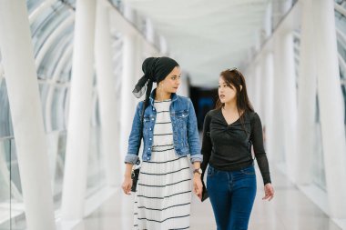 Gündüz vakti köprüde farklı etnik kökenlere sahip iki arkadaş. Biri Malezyalı Müslüman bir kadın, diğeri de Çinli bir Asyalı. İkisi de genç, enerjik ve çekici..