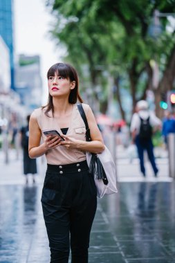 Onun smartphone kullanarak Genç, çekici Çinli Asyalı kadın