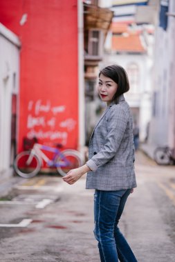young beautiful asian woman walks down an alley
