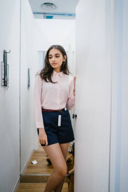 Yeni giyim moda salonu bir alışveriş merkezinde bir montaj odasında çalışıyor bir genç ve güzel Hint Asyalı kadın portresi.