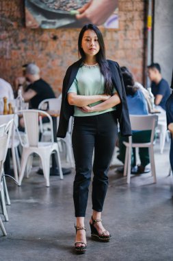 Gündüz vakti genç, seksi ve çekici bir Asyalı kadının portresi. O nane yeşili bir kazak giyiyor.