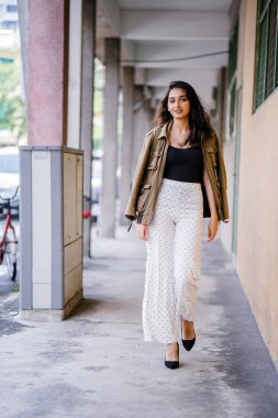 Gün boyunca bir geçit Asya'da bir şehirde yürürken bir uzun boylu, güzel, ince ve zarif Hint Asyalı kadın portresi. O zarif giyindi ve bir ceket omuzları üzerinde bol dökümlü vardır.