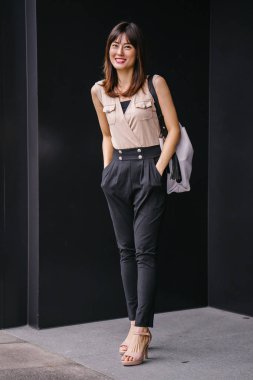 Bir çalışma hanım o pozlar ve onun baş shot siyah bir arka plan için gülümsüyor olarak stüdyo portresi