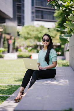 Genç ve çekici bir Asyalı kadın öğrenci oturur ve gün boyunca bir üniversite kampüsünde onu dizüstü bilgisayar üzerinde çalışır. O, o çalışırken gelişigüzel giyinmiş. 
