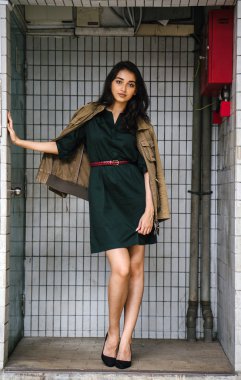 Hint Asyalı kadın Genç, uzun boylu, ince ve zarif bir portre için poz veriyor. O rahat ve şık rahat giysiler giyiyor ve bir adamın ceketi omuzları üzerinde bol dökümlü vardır. 