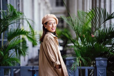 Gün içinde şık, zarif ve güzel orta yaşlı Asyalı bir kadının portresi. O bir mahkeme evin gri koridorunda pozlar olarak gülümsüyor.