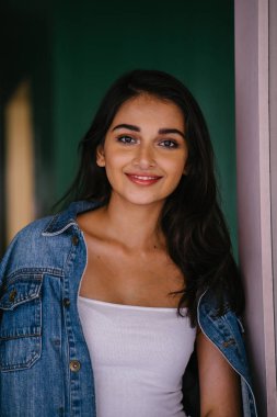 gün boyunca şehirde genç ve zarif Hint Asyalı kadın portresi. O bir retro Kot ceket giyiyor