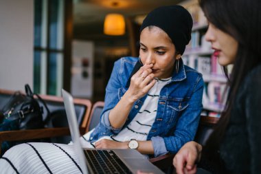 Müslüman bir Orta Doğulu kadın Çinli bir meslektaşıyla iş görüşmesi yapıyor..