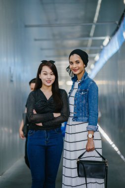 Gündüz vakti köprüde farklı etnik kökenlere sahip iki arkadaş. Biri Malezyalı Müslüman bir kadın, diğeri de Çinli bir Asyalı. İkisi de genç, enerjik ve çekici..