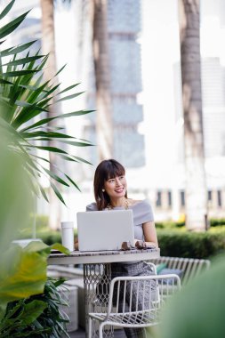 Modern dizüstü bilgisayar kullanarak çekici, kendine güvenen ve başarılı bir Çinli Asyalı kadının portresi