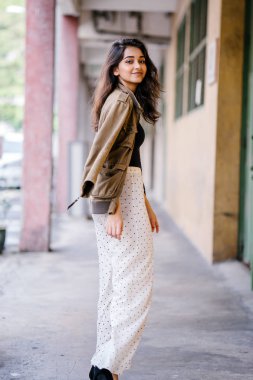 Gün boyunca bir geçit Asya'da bir şehirde yürürken bir uzun boylu, güzel, ince ve zarif Hint Asyalı kadın portresi. O zarif giyindi ve bir ceket omuzları üzerinde bol dökümlü vardır.