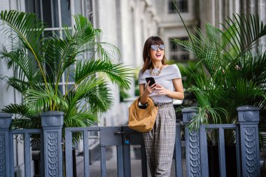 Çekici, kendine güvenen ve başarılı bir Çinli Asyalı kadının portresi. Akıllı telefonunu tutuyor. 