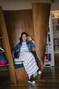 Genç, zarif ve çekici Malezyalı Müslüman kadın gün boyunca elbise ve kot ceket giyiyor..