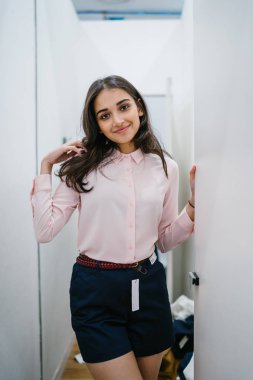 Yeni giyim moda salonu bir alışveriş merkezinde bir montaj odasında çalışıyor bir genç ve güzel Hint Asyalı kadın portresi.