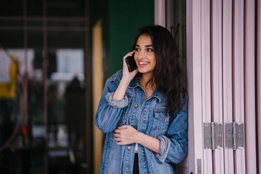 Onun Smartphone'da bahseden bir güzel, uzun boylu, zarif ve genç Hintli Asyalı kadın portresi. O bir retro Kot ceket giyiyor 