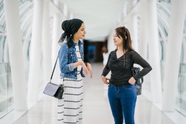 Gündüz vakti köprüde farklı etnik kökenlere sahip iki arkadaş. Biri Malezyalı Müslüman bir kadın, diğeri de Çinli bir Asyalı. İkisi de genç, enerjik ve çekici..