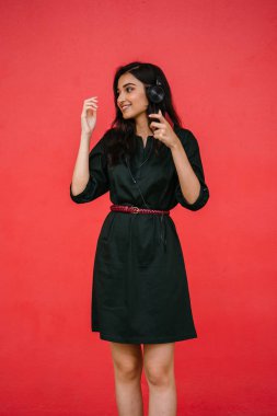 Bir güzel, Genç ve çekici Hint Asyalı kadın bir yeşil elbise ve kırmızı bir arka plan kırmızı kemer Studio portresi