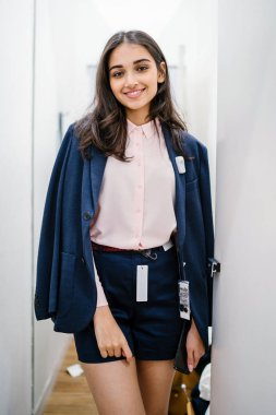 Yeni giyim moda salonu bir alışveriş merkezinde bir montaj odasında çalışıyor bir genç ve güzel Hint Asyalı kadın portresi.