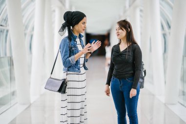 Gündüz vakti köprüde farklı etnik kökenlere sahip iki arkadaş. Biri Malezyalı Müslüman bir kadın, diğeri de Çinli bir Asyalı. İkisi de genç, enerjik ve çekici..