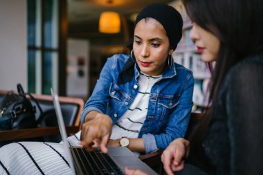 Müslüman bir Orta Doğulu kadın Çinli bir meslektaşıyla iş görüşmesi yapıyor..