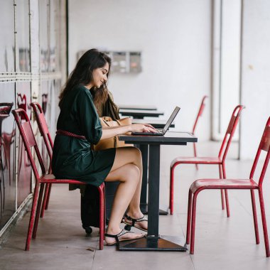 genç üniversite öğrencisi (Hint Asyalı kadın) eğitim ve gün boyunca dizüstü bilgisayar bir masa başında çalışma
