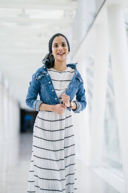 Genç, zarif ve çekici Malezyalı Müslüman kadın gün boyunca elbise ve kot ceket giyiyor..