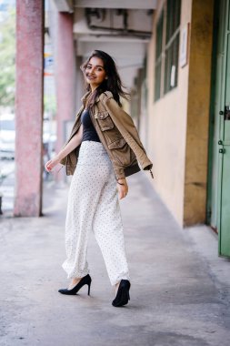 Gün boyunca bir geçit Asya'da bir şehirde yürürken bir uzun boylu, güzel, ince ve zarif Hint Asyalı kadın portresi. O zarif giyindi ve bir ceket omuzları üzerinde bol dökümlü vardır.