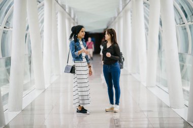 Gündüz vakti köprüde farklı etnik kökenlere sahip iki arkadaş. Biri Malezyalı Müslüman bir kadın, diğeri de Çinli bir Asyalı. İkisi de genç, enerjik ve çekici..
