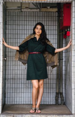 Hint Asyalı kadın Genç, uzun boylu, ince ve zarif bir portre için poz veriyor. O rahat ve şık rahat giysiler giyiyor ve bir adamın ceketi omuzları üzerinde bol dökümlü vardır. 