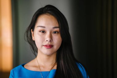 Kendinden emin, genç, güzel ve kendinden emin Asyalı bir kadının portresi.