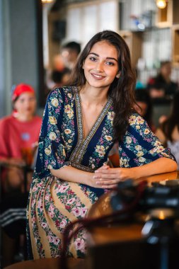 portre baş shot, kendine güvenen, Genç ve çekici Hint Asya kız sıcak aydınlatılmış bir trendy Cafe