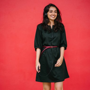 Bir güzel, Genç ve çekici Hint Asyalı kadın bir yeşil elbise ve kırmızı bir arka plan kırmızı kemer Studio portresi