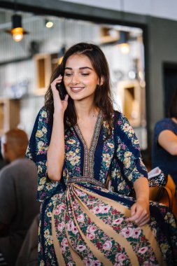 Bir kafede onu smartphone o görüşmeler olarak gündüzleri çatık bir genç ve çekici Hint Asyalı kadın portresi