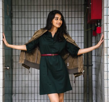 Hint Asyalı kadın Genç, uzun boylu, ince ve zarif bir portre için poz veriyor. O rahat ve şık rahat giysiler giyiyor ve bir adamın ceketi omuzları üzerinde bol dökümlü vardır. 