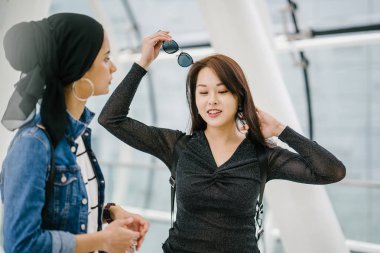 Gündüz vakti köprüde farklı etnik kökenlere sahip iki arkadaş. Biri Malezyalı Müslüman bir kadın, diğeri de Çinli bir Asyalı. İkisi de genç, enerjik ve çekici..