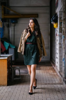 Hint Asyalı kadın Genç, uzun boylu, ince ve zarif bir portre için poz veriyor. O rahat ve şık rahat giysiler giyiyor ve bir adamın ceketi omuzları üzerinde bol dökümlü vardır. 